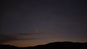 "El cometa Tsuchinshan-Atlas cruzando el cielo nocturno, visible desde el hemisferio norte durante varias noches consecutivas, mientras su cola brilla en dirección opuesta al sol."