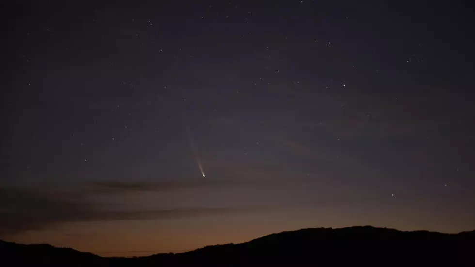 "El cometa Tsuchinshan-Atlas cruzando el cielo nocturno, visible desde el hemisferio norte durante varias noches consecutivas, mientras su cola brilla en dirección opuesta al sol."